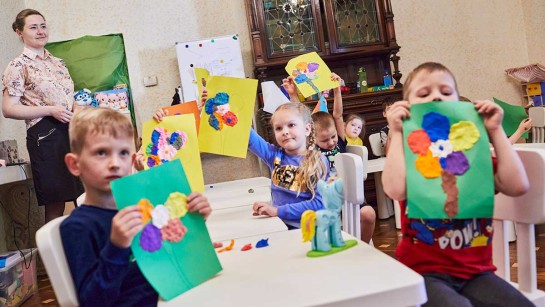 Barn på flykt från Ukraina visar sina teckningar i en skola i Bukarest.